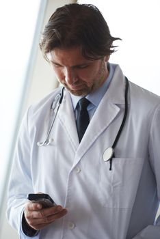 handsome doctor speaking on cellphone at modern hospital indoors