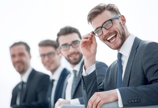 close up.smiling businessman sitting on the background of colleagues.business concept