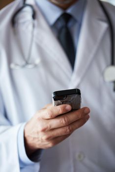 handsome doctor speaking on cellphone at modern hospital indoors