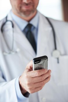 handsome doctor speaking on cellphone at modern hospital indoors