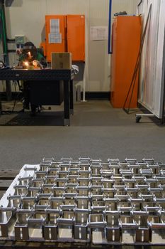 The first phase of metal and aluminum processing. Processed products from CNC machines stacked on a pallet in a large modern factory. High quality photo