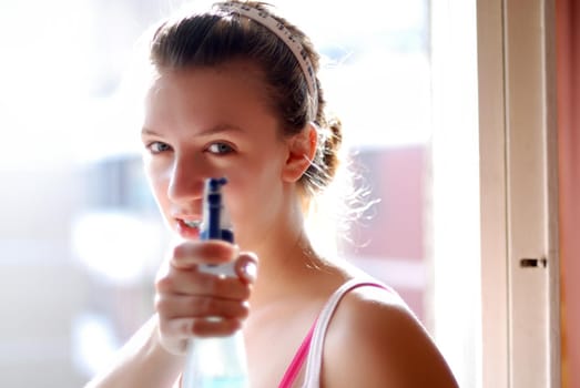 Young woman cleaning the window