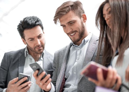 close up.business colleagues reading a text on smartphones.people and technology