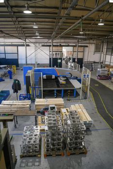 The first phase of metal and aluminum processing. Processed products from CNC machines stacked on a pallet in a large modern factory. High quality photo