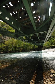 beautiful bridge in nature over wild river