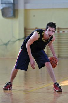 one healthy young  man play basketball game in school gym indoor