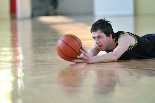 one healthy young  man play basketball game in school gym indoor