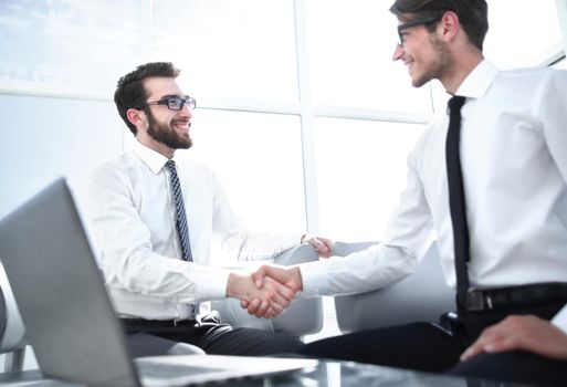 business partners shake each other sitting in the office. the concept of cooperation