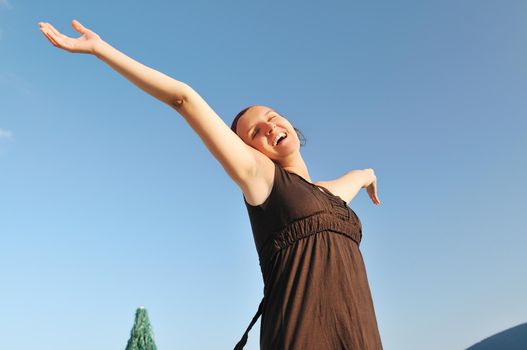 young happy woman with arms wide open representing freedom concept 