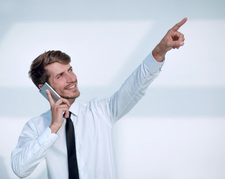 portrait businessman speaking on the phone celebrating with hand in the air and finger pointing up