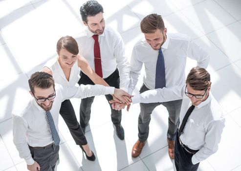 top view. young employees folding their hands together. photo with copy space