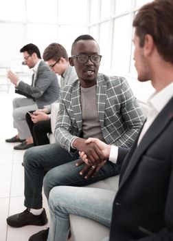 handshake of business people sitting in the office lobby.business concept