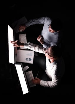 top view .two employees discussing financial data.the concept of overtime work