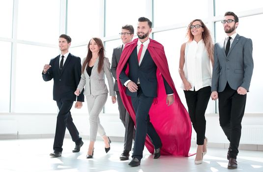 businessman in a red cloak marching with the business team.business concept