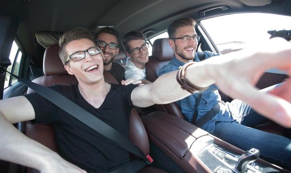 close up. a group of friends point to the road while sitting in the car. the concept of friendship