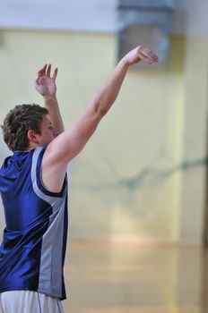 one healthy young  man play basketball game in school gym indoor