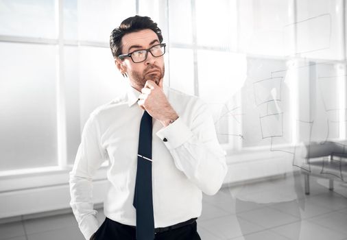 pensive businessman standing near a transparent Board.photo with copy space