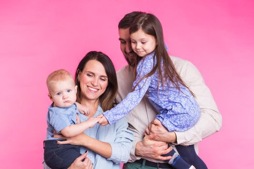 Portrait of Young Happy Mixed Race Family over pink background