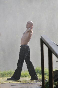 standing man with wide opened arms with waterfalls in background and representing freshness healthy lifestyle and success concept