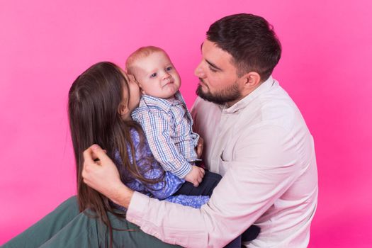 Father with children having fun on pink background.