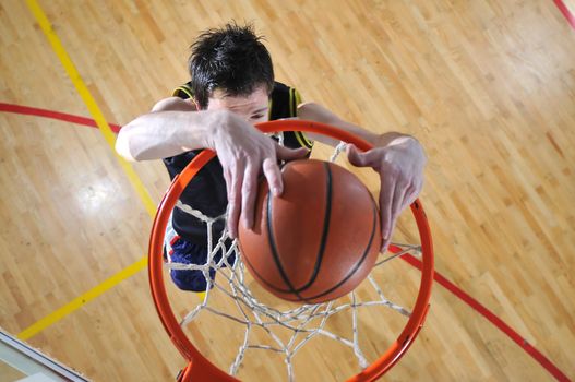 one healthy young  man play basketball game in school gym indoor