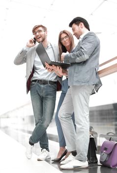 business colleagues using their gadgets standing in the office lobby. photo with copy space