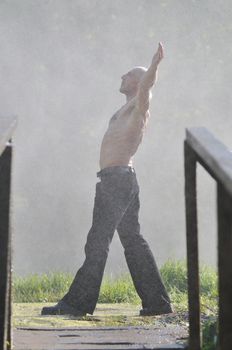 standing man with wide opened arms with waterfalls in background and representing freshness healthy lifestyle and success concept