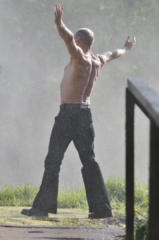 standing man with wide opened arms with waterfalls in background and representing freshness healthy lifestyle and success concept