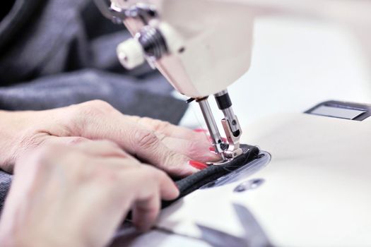 woman Hands of Seamstress Using Sewing Machine tailor and new clothes fahion reparation concept