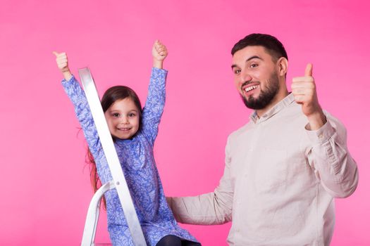 Father with his baby daughter shows thumb up.