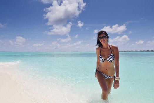 beautiful and happy young woman on beach have fun and relax on summer vacation  over the crystal clear sea