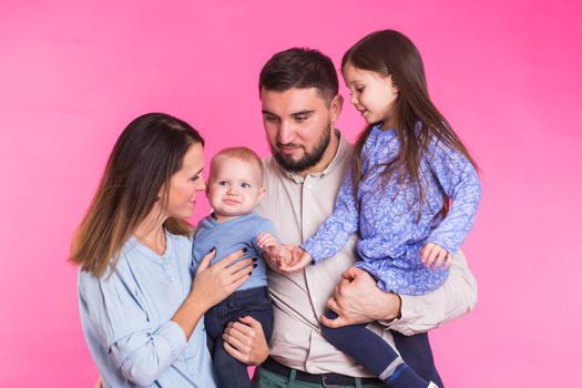 Portrait of Young Happy Mixed Race Family over pink background