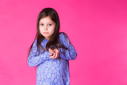 Portrait of a charming brunette little girl, isolated on gray background