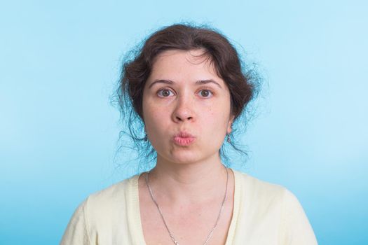 Concerned scared woman on blue background in studio