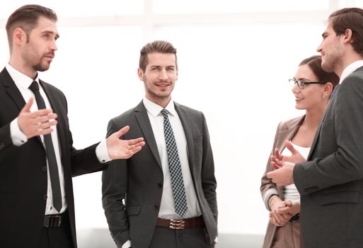 businessman talking to his colleagues standing in the office.the concept of teamwork