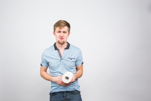 Young Man with Toilet Paper on the White Background - health problem concept.