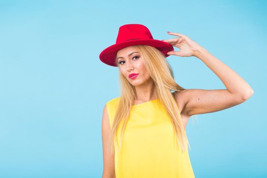 Portrait of smiling blonde woman in fashionable look on blue background. Style, fashion, summer and people concept.
