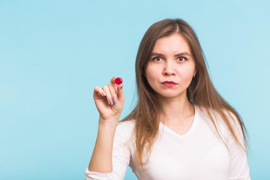 Young woman with red tablet on blue background.