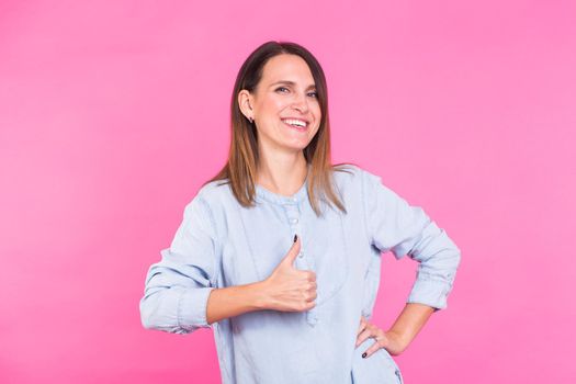 Smiling Woman in shirt posing in studio on pink background.