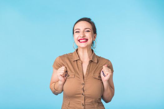 Portrait of young beautiful ginger woman with freckles cheerfuly smiling looking at camera. Isolated on pastel blue background. Copy space.