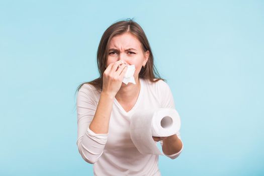 Young woman with handkerchief. Sick girl isolated has runny nose on blue background.