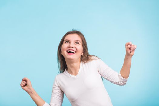 Energy girl dances on blue background in studio