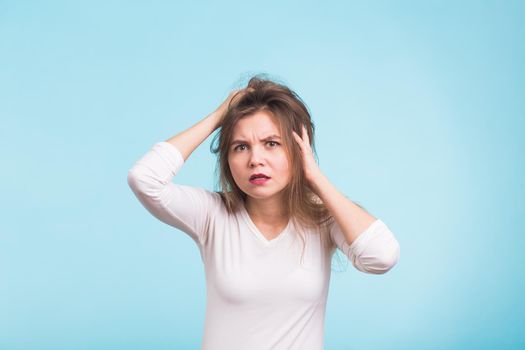 Concerned scared woman on blue background in studio