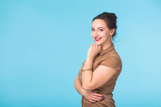 Portrait of young beautiful ginger woman with freckles cheerfuly smiling looking at camera. Isolated on pastel blue background. Copy space.