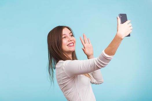 Young woman talking with friend through a video call on a smartphone. Beautiful girl having a video chat with man on mobile phone