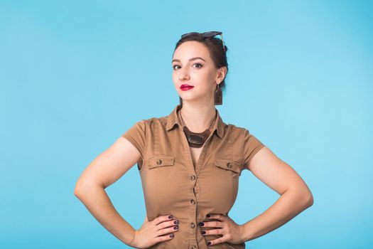 Portrait of young beautiful ginger woman with freckles cheerfuly smiling looking at camera. Isolated on pastel blue background. Copy space.