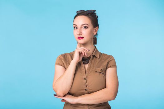 Portrait of young beautiful ginger woman with freckles cheerfuly smiling looking at camera. Isolated on pastel blue background. Copy space.