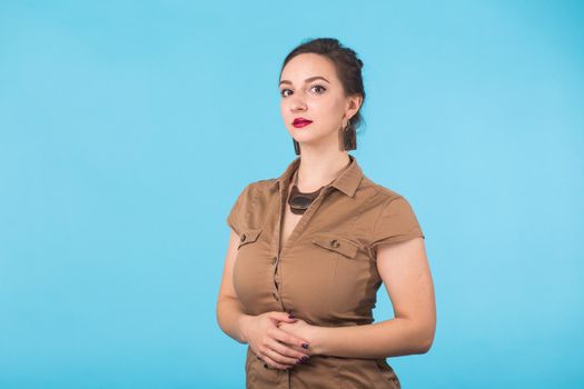 Portrait of young beautiful ginger woman with freckles cheerfuly smiling looking at camera. Isolated on pastel blue background. Copy space.