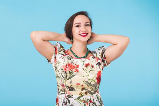 Portrait of young beautiful ginger woman with freckles cheerfuly smiling looking at camera. Isolated on pastel blue background. Copy space.