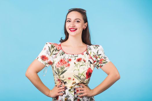 Portrait of young beautiful ginger woman with freckles cheerfuly smiling looking at camera. Isolated on pastel blue background. Copy space.